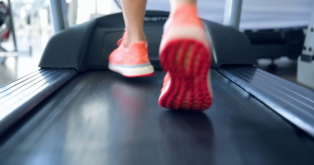 A person in red shoes running on Treadmill for Marathon Training