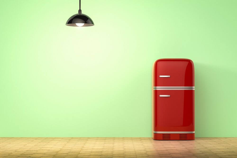 A red retro fridge inside a wide room